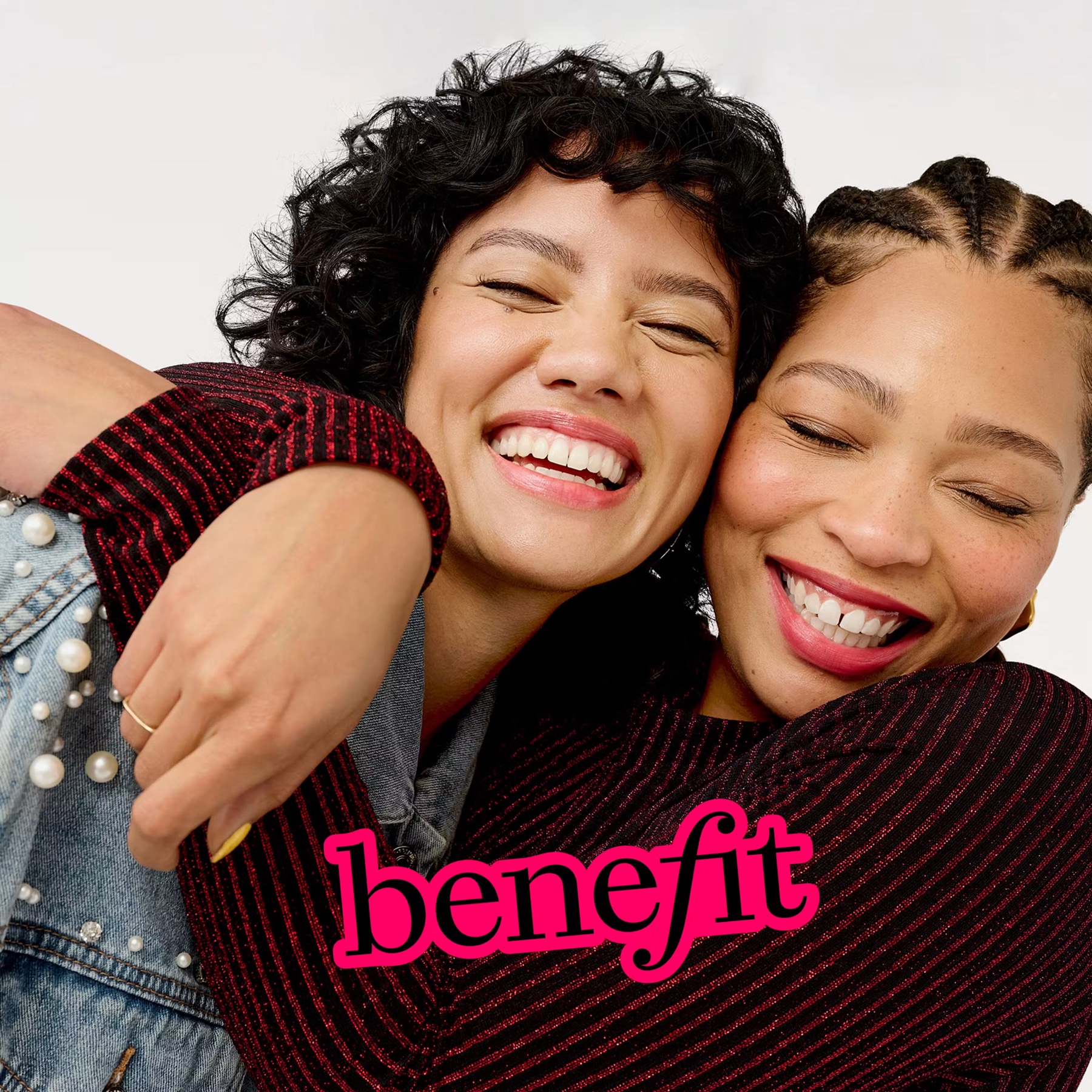 Two smiling Benefit customers embracing